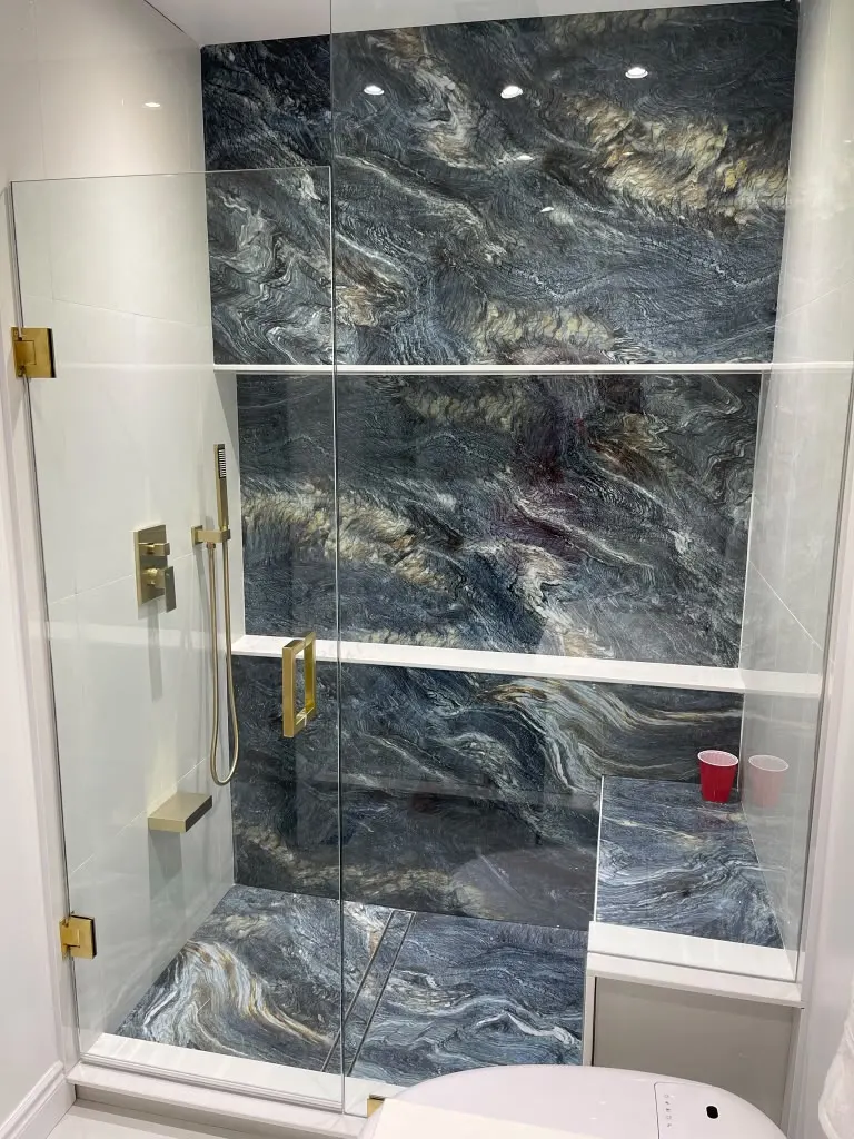 Shower with blue and gold marble feature wall and brass hardware