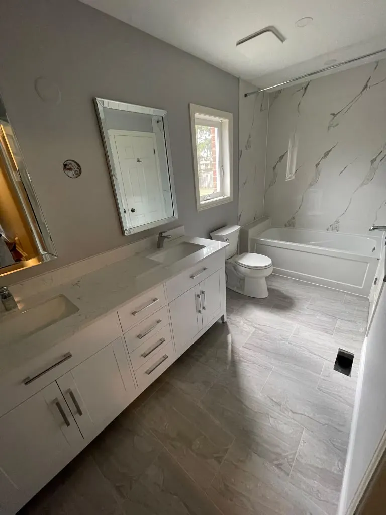 Double vanity bathroom with marble tub surround