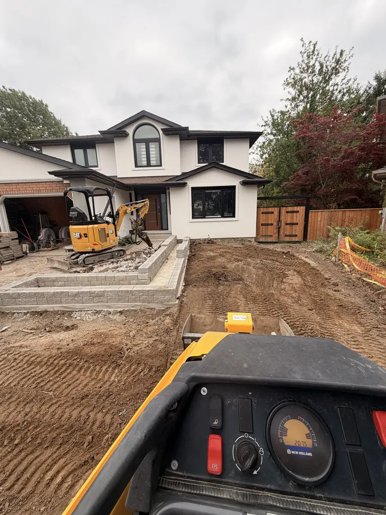 Excavator and skid steer preparing a home entrance and driveway
