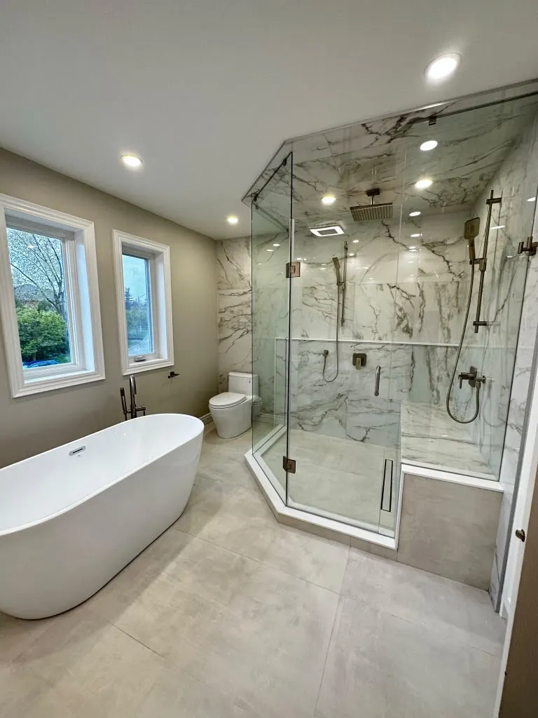 Freestanding tub and corner glass shower in a bright bathroom