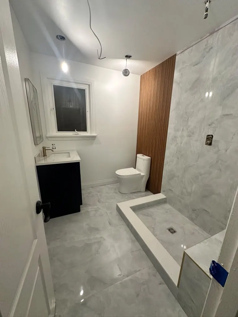 Curbless shower with slatted wood accent and marble tile
