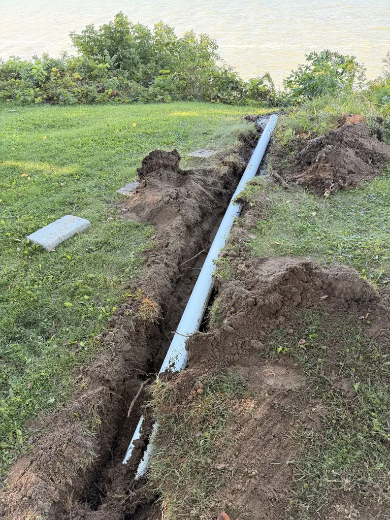 Trench with drainage pipe installed in a lakefront yard